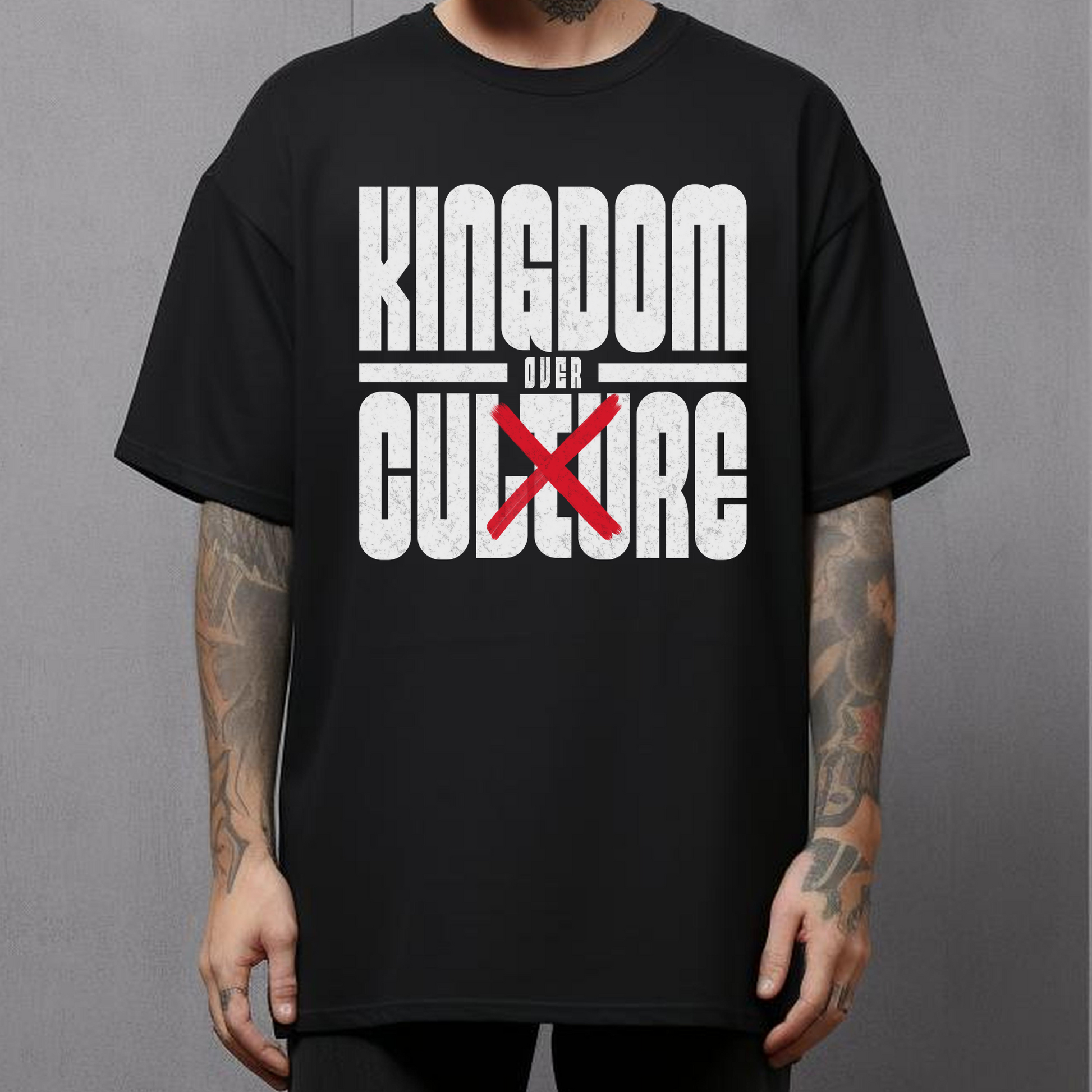 tattooed man wearing a christian streetwear tshirt that says kingdom over culture in bold lettering