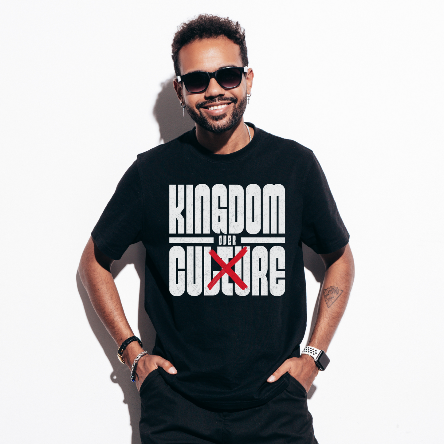 a man wearing a black crewneck short sleeve edgy christian shirt in a christian streetwear style that says kingdom over culture