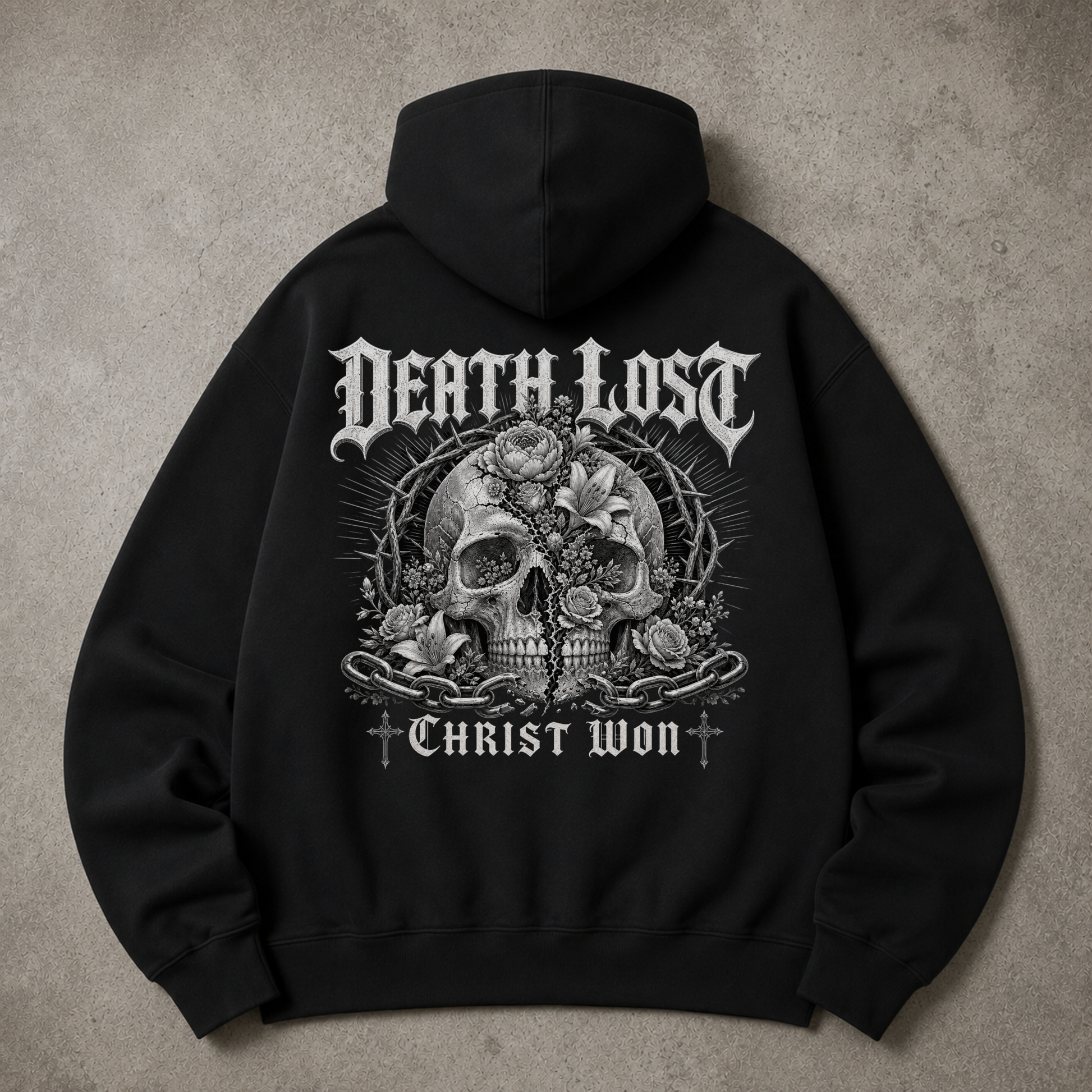 A black pullover hoodie shown from the back, featuring the phrase 'Unashamed of the Gospel of Christ' printed in a large white cursive script across the back, laid flat on a textured gray surface.