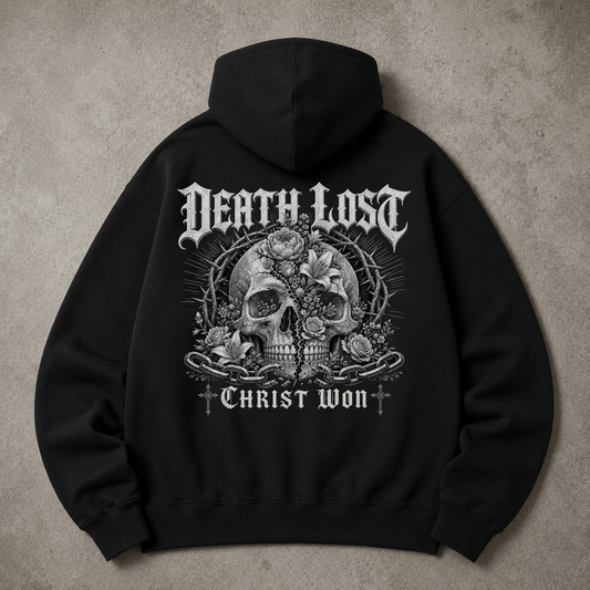 A black pullover hoodie shown from the back, featuring the phrase 'Unashamed of the Gospel of Christ' printed in a large white cursive script across the back, laid flat on a textured gray surface.