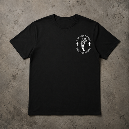 A black short-sleeve crewneck t-shirt with a white circular graphic on the left chest, laid flat on a textured gray concrete background.